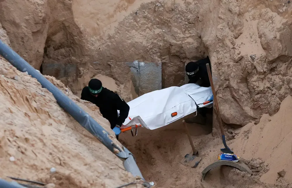 milicianos-de-hamas-cargan-un-cuerpo-de-un-supuesto-rehenes-rescatado-de-un-tunel-en-khan-yunis-foto-reutersramadan-abed-WPLHAYORDPHDD2HDA6CDLGFXPQ