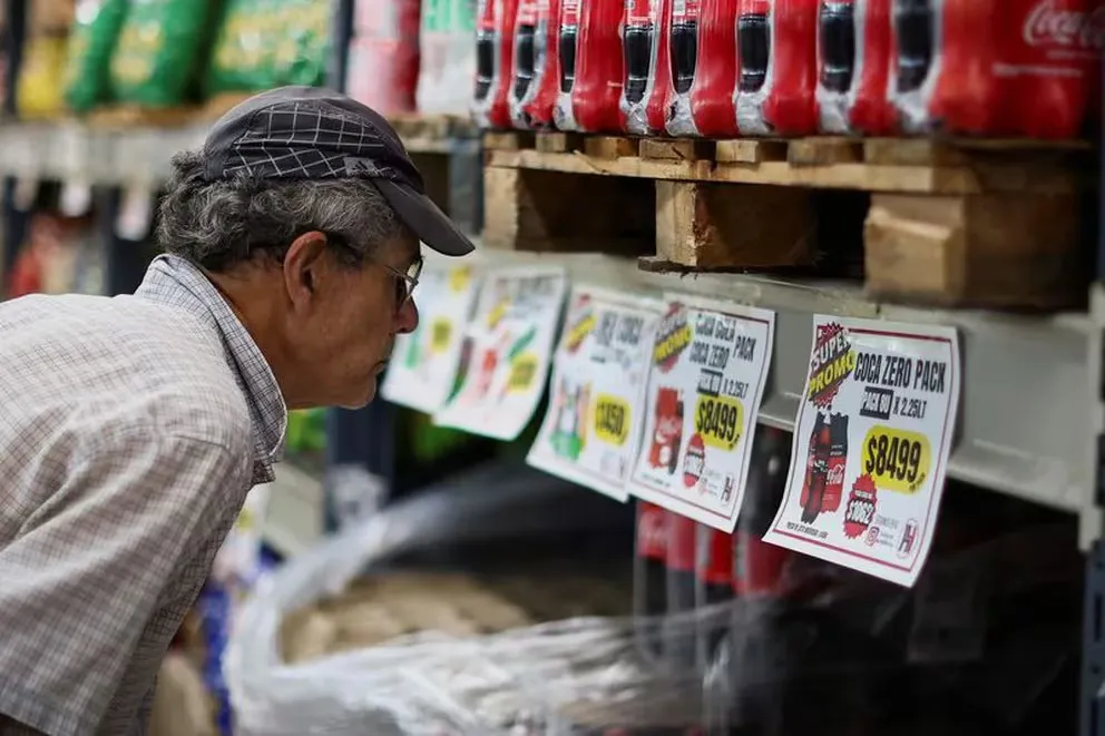 Un hombre revisa los precios de los refrescos en un supermercado en Buenos Aires mientras Argentina lucha contra la inflación.